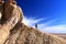 Unrecognisable man climbing a coloured hill with exploding like cloud movement in Tsagaan Suvraga Â«Â white stupaÂ Â» in the Gobi